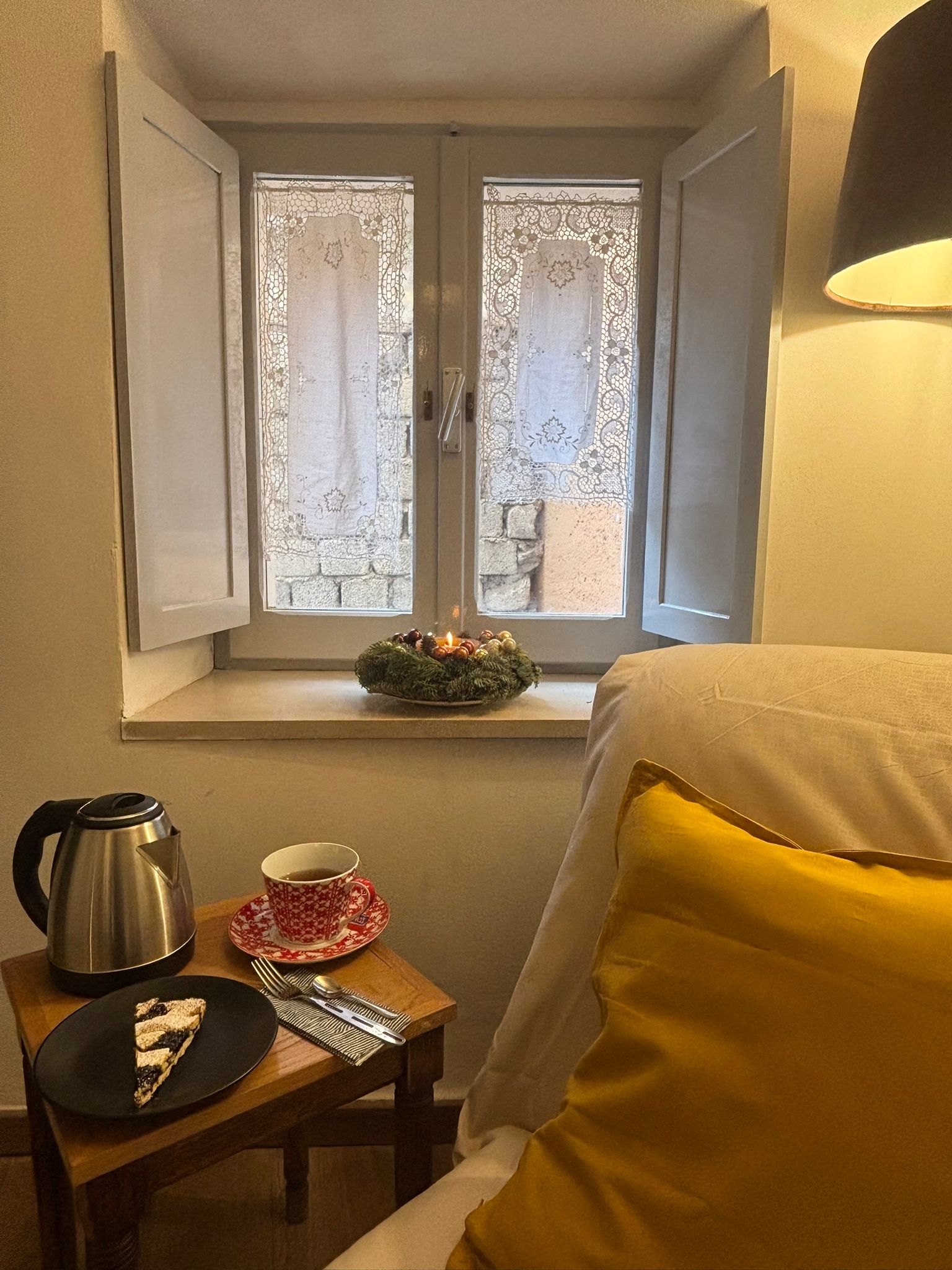 Colazione servita a letto con candele alla finestra